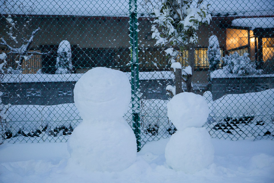 降り続く雪で、雪だるまの顔が埋まりつつある