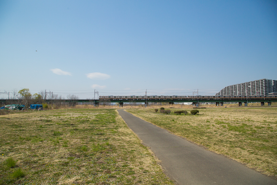 青空と地面の間を電車が横切る