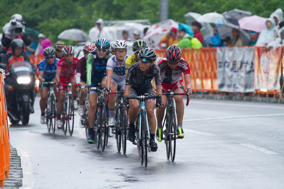 智野真央（Neilpryde Men's Club Pro Cycling）が引いてゴールラインを通過する先頭集団