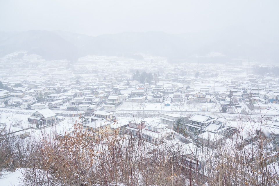 雪化粧した村を見下ろす