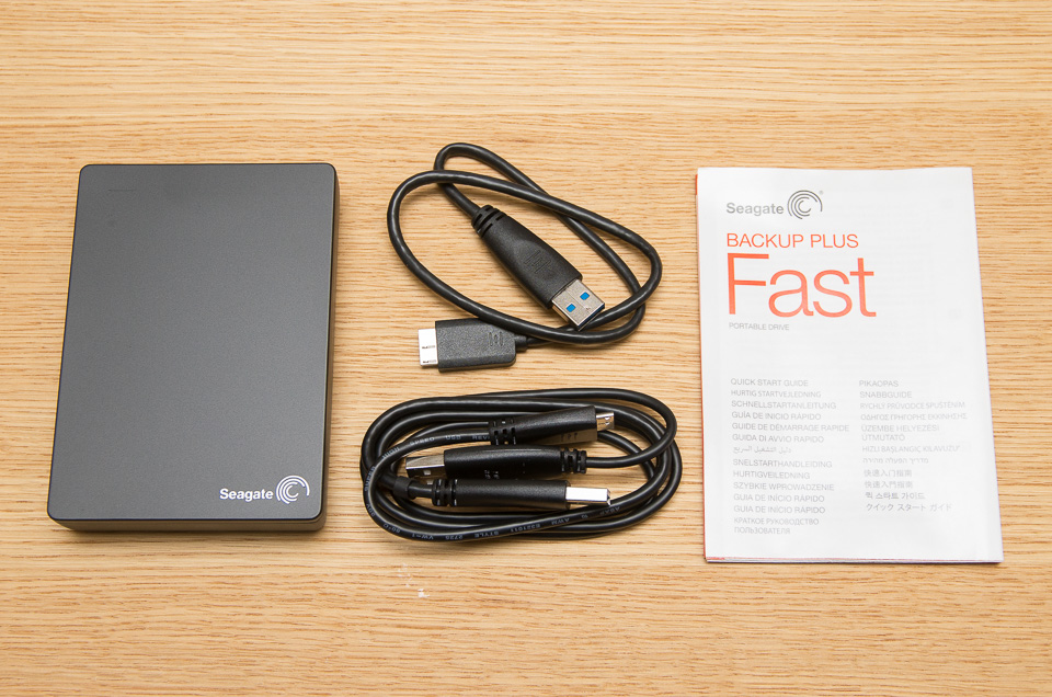 Seagate『Backup Plus Fast 4TB Portable External Hard Drive USB3.0』の本体と付属品。バスパワー型USBケーブル、給電分岐型USBケーブル、取扱説明書